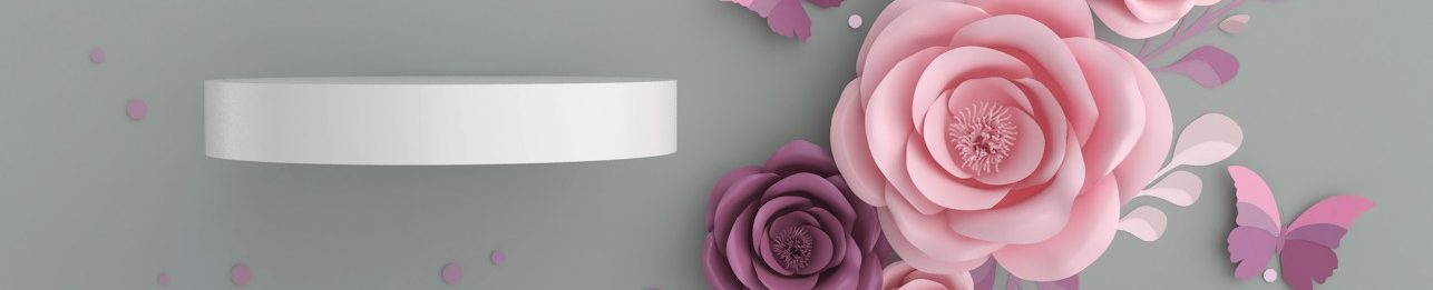 Blumen Design Weißer Cremetop mit rosa Blumen auf grauem Hintergrund.