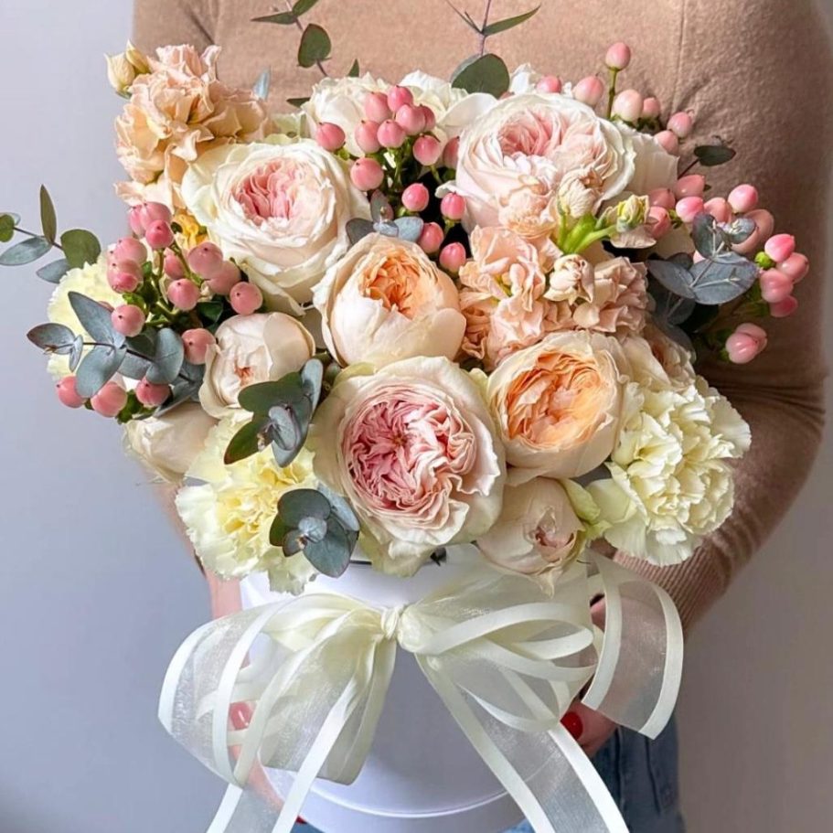 Vom Floristen Blumenlieferung Boqueteria Ein Strauß aus orangefarbenen Rosen in kraftpapierartiger Verpackung.